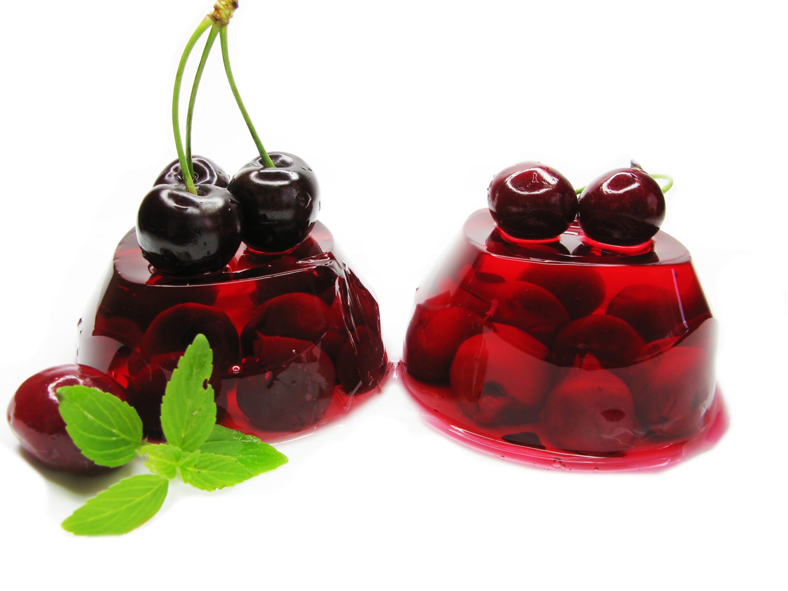 Assorted translucent jelly candies and gummy bears in vibrant red, yellow, and orange hues, colored with BioconColors natural colorants.